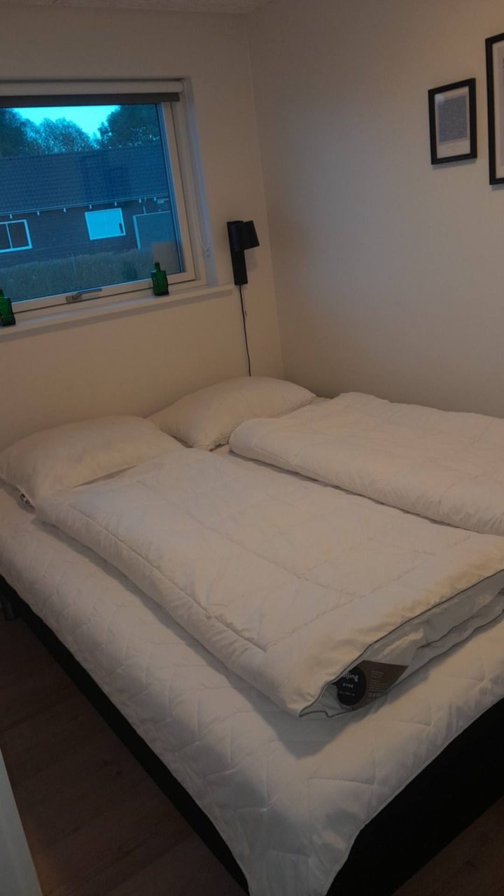 Det samme soveværelse klargjort: to dyner lagt ud hver sin side og puderne på plads, begge dele uden betræk